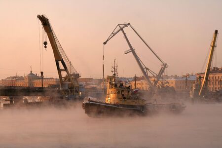 a  small yellow river ice breaker in a portの写真素材