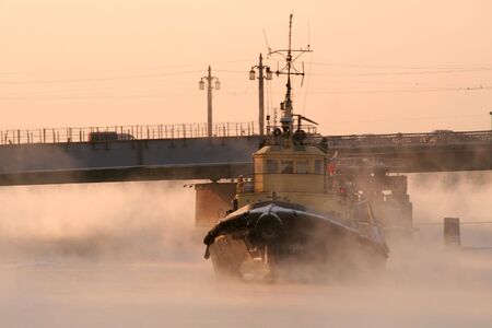 a small river ice breaker under a bridgeの写真素材