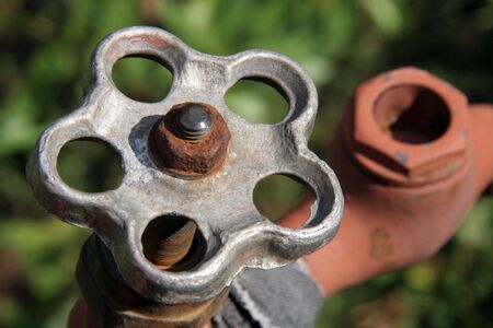 an old rusty tap on a green backgroundの写真素材