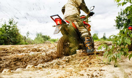 The man on a motorcycle rides through the mudの写真素材