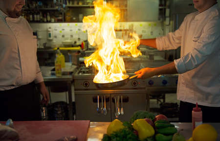 Chefs doing flambe on foodの写真素材
