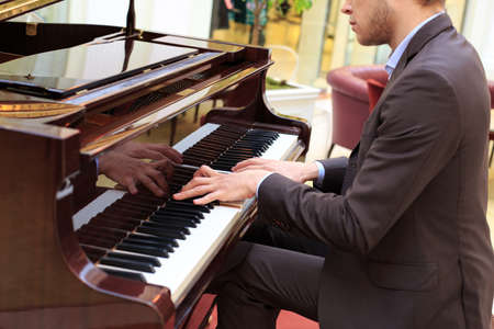 Handsome young men playing pianoの写真素材