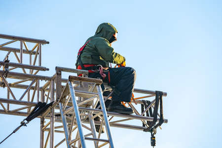 Industrial climber in uniform sitting ts on a building structureの写真素材