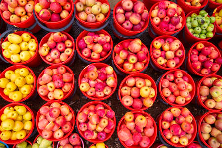 Bright colored apples in bucketsの写真素材