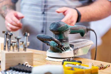 Man sawing wood with a circular saw on a workbench in motionの写真素材