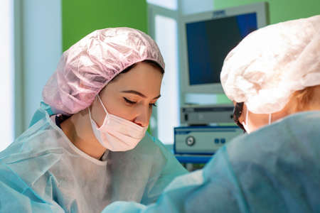 female surgeon doctor or intern wearing protective mask and hat.の写真素材