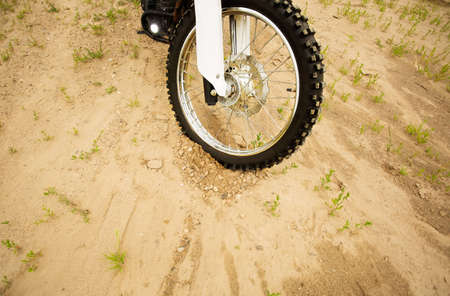 Dirtbike front wheel on muddy rural road in countryside.の写真素材