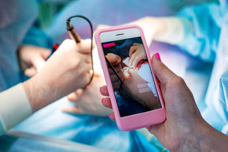 Surgeons operating a patient in operating roomの写真素材