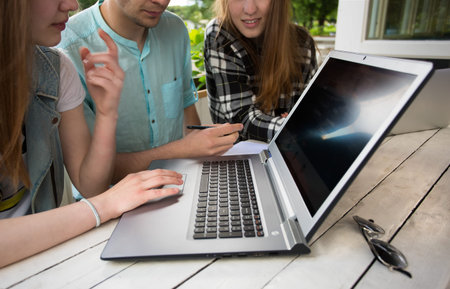 Group of young student using laptop outdoorの写真素材