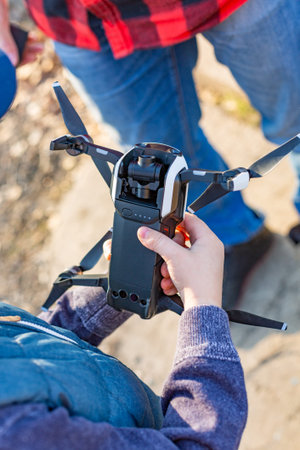 male and childrens hands holding drone and going to start a drone in the park. Preparing the launch of droneの写真素材
