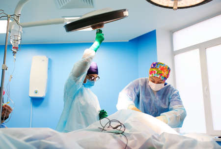 Surgeon adjusts the lamp  in operating roomの写真素材