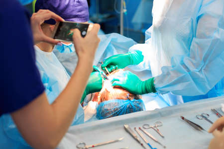 Surgeons operating a patient in operating roomの写真素材