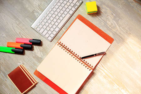 Diary notebook and colored pens on wooden background.の写真素材