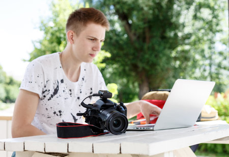 Attractive young man student using laptop outsideの写真素材