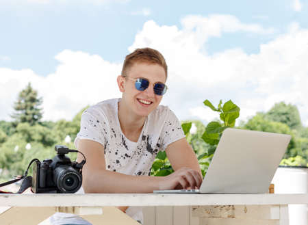 Attractive young man student using laptop outsideの写真素材
