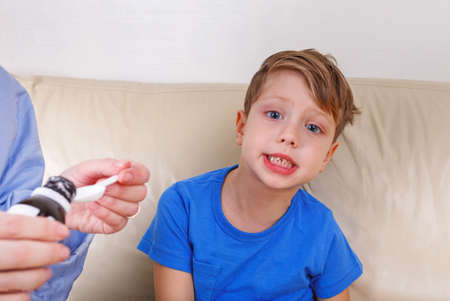 The boy is sick. Mom treats drugsの写真素材