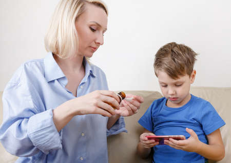 The boy is sick. Mom treats drugsの写真素材