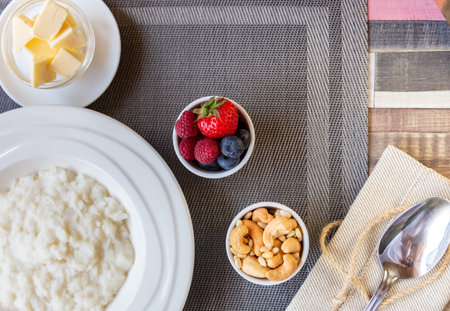 Healthy breakfast. Rice porridge bowl with berries and nuts on the table, hot and healthy breakfast food, top viewの写真素材