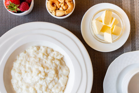 Healthy breakfast. Rice porridge bowl with berries and nuts on the table, hot and healthy breakfast...