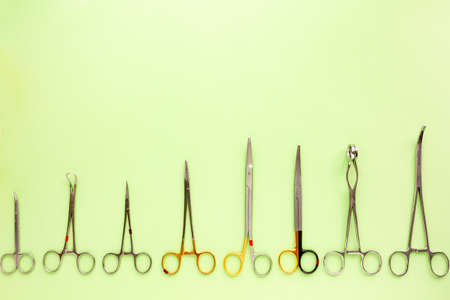 Medical equipments including surgical instruments on green background, top view