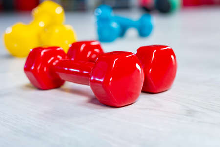 Colorfull modern dumbbells on a wooden floorの写真素材