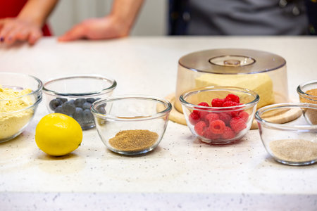 Ingredients for cooking strawberry pie or cake on white background. Side view. Flour, milk, sugar,...