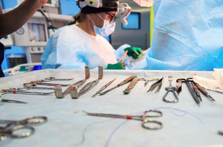 Surgical tools lying on table in surgical theatre. Steel medical instruments ready to be used. Surgery and emergency conceptの写真素材
