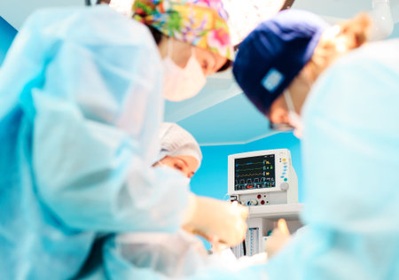 Surgery, medicine and people concept - three surgeons in operating room at hospital during their work.の写真素材
