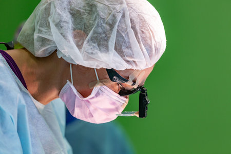 female surgeon doctor wearing protective mask and hat during the operation. Healthcare, medical...
