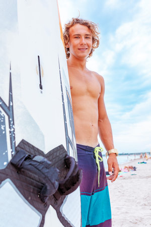 Handsome man walk with white blank surfing board wait for wave to surf spot at sea ocean shore....
