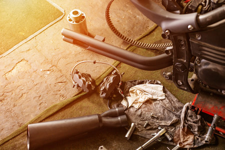Cropped close up shot of beautiful and custom made motorcycle in the workshopの写真素材