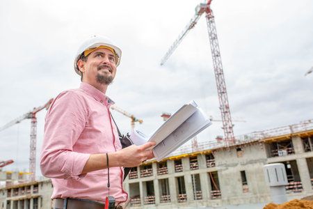 Portrait of architect at work with helmet in a construction site,reads the plan.
