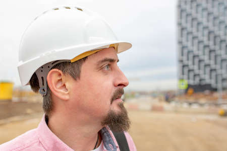 Portrait of architect at work with helmet in a construction site,reads the plan.の写真素材
