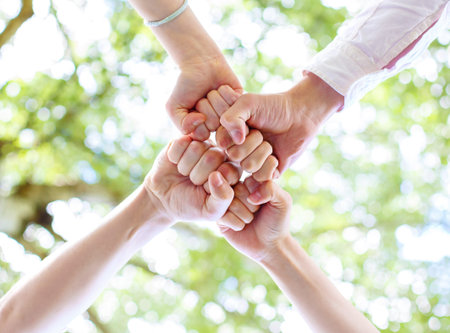 Teenagers joined their hands in a circle