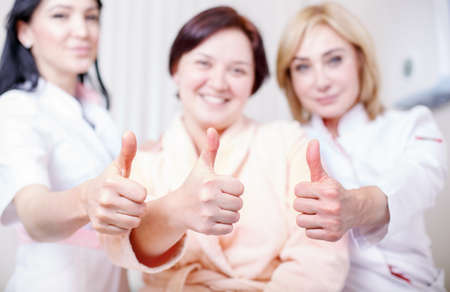 Doctors with a happy patient show likeの写真素材