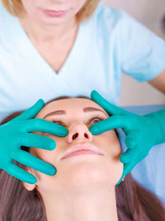 Cosmetic surgeon examining female client in clinik  before plastの写真素材