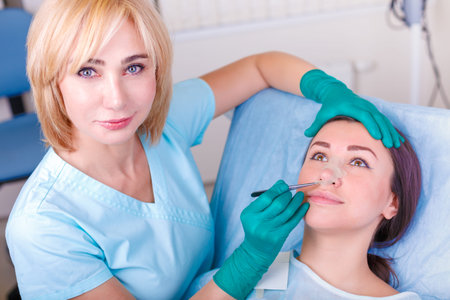 Cosmetic surgeon examining female client in clinik  before plast