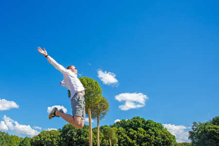 Guy is hovering in the air. The guy is hovering in the air against the background of a fountainの写真素材