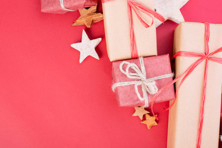 Christmas composition. Christmas red decorations, stars and gift boxes on red background. Flat lay,...