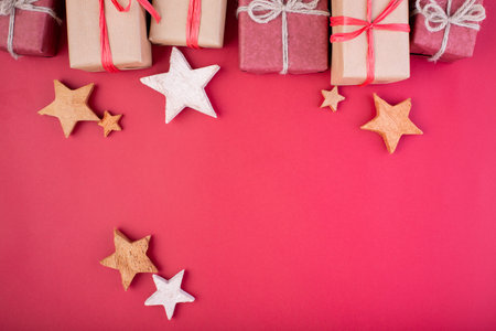 Christmas composition. Christmas red decorations, stars and gift boxes on red background. Flat lay,...