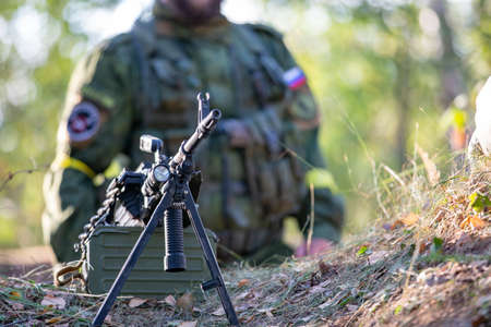 Sniper armed with large caliber, sniper rifle, shooting enemy targets on range from shelter, sitting in ambushの写真素材