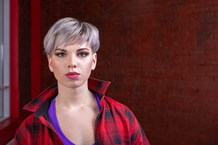 portrait of a girl close-up of a beautiful young sexy blonde with short hair in a red plaid shirt, hipsterの写真素材