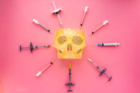 Flat lay of medical instruments with human skull on rose background. Mock up health care medical background.の写真素材