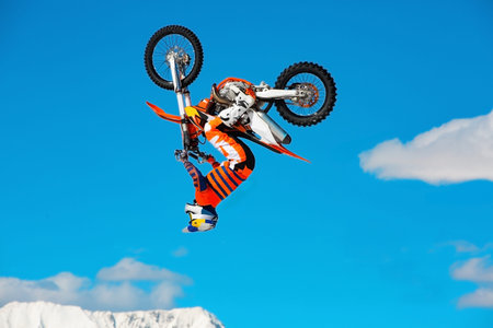Racer on motorcycle participates in motocross cross-country in flight, jumps and takes off on...