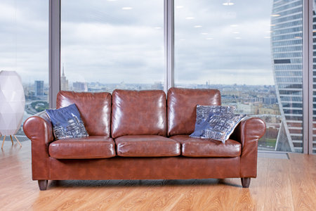 brown armchair against the backdrop of a huge window view from the panoramic windows.