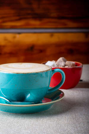 Beautiful Delicious Latte art, Blue coffee cup with Brown sugar on wooden background.の写真素材