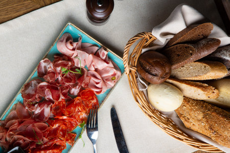 assorted cold meat, prosciutto, slices ham, beef jerky, salami, meat and mustard on black...