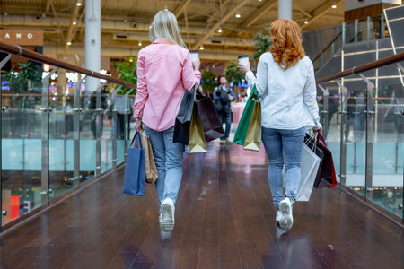 Happy young women with shopping bags enjoying in shopping, girls are having fun with their...