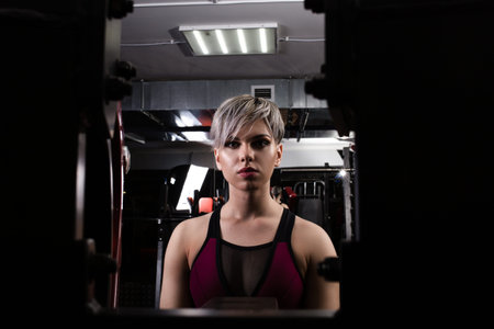Beautiful sport girl is engaged on a simulator in the gym. Pretty girl with the beautiful tightened...