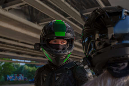 Portrait of bikers man and woman in helmets look at each other. Motorcycle love concept. Extreme ridersの写真素材